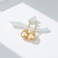 Golden South Sea Pearl 11.0-12.0 mm Add some shimmer and sparkle to your look with these Golden South Sea Pearl & Cubic Zirconia Luise Earrings. These earrings feature an elegant and classic gold button setting that provides the perfect backdrop for the fresh water pearl. These pearl earrings are sure to be a great addition to any outfit, whether you're dressing up or going casual. Their timeless style makes them an absolute must-have for any jewelry lover and they are a great way to update your Classic Gold Diamond Clip-on Earrings, Elegant Formal Crystal Pearl Earrings, Classic Gold Diamond Drop Earrings, Classic Cubic Zirconia Earrings, Elegant Bridal Earrings In Diamond White For Formal Occasions, Elegant Diamond White Bridal Earrings For Formal Events, Elegant Diamond White Bridal Earrings For Formal Occasions, Elegant White Bridal Earrings For Formal Occasions, Classic Pearl Earrings With Cubic Zirconia For Party