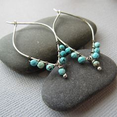 Each pair is handcrafted with sterling silver and features beautiful turquoise stones, measuring 2 inches long. Add a pop of color to your look with these unique and eye-catching earrings. Unique Handmade Turquoise Hoop Earrings, Turquoise Hoop Earrings With Natural Stones As Gift, Turquoise Natural Stone Hoop Earrings As Gift, Turquoise Sterling Silver Hoop Earrings For Pierced Ears, Handmade Turquoise Sterling Silver Hoop Earrings, Turquoise Sterling Silver Nickel-free Hoop Earrings, Artisan Nickel-free Turquoise Hoop Earrings, Turquoise Teardrop Sterling Silver Hoop Earrings, Nickel-free Turquoise Sterling Silver Earrings