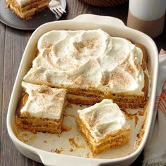 a pan filled with cake and frosting on top of a wooden table