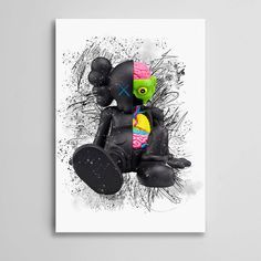 a black teddy bear sitting on top of a white table next to a wall mounted poster