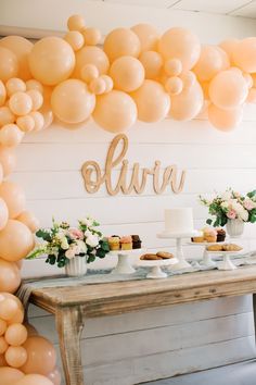 a table topped with cakes and desserts under balloons