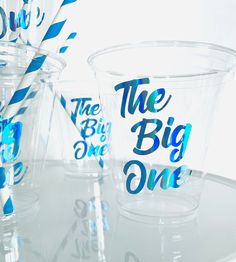 plastic cups and straws with the words the big one printed on them