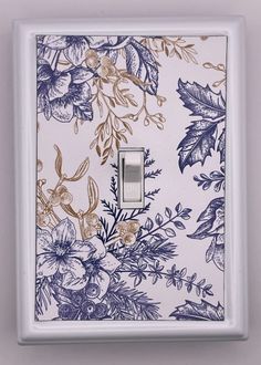 a white light switch with blue and gold flowers on it's cover is shown