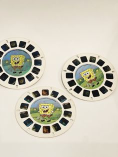 three spongebob plates sitting on top of a white table