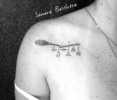 a black and white photo of a woman's shoulder with a tattoo on it