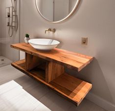 a bathroom sink sitting under a round mirror