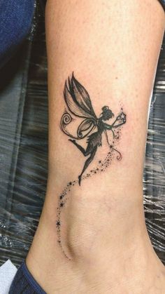 a woman's foot with a small tattoo on the side of her leg and a fairy