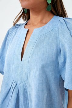 The Finley Flutter Sleeve Top is an effortlessly chic style staple. In a fresh chambray hue, this blouse has a flattering silhouette, oversized flutter sleeves, and a V-neckline that can be dressed up or down with a quick change of accessories. Pair with gold jewelry for everything from work to brunch this season. V-neckline Oversized short flutter sleeves Boxy fit Slightly cropped Material: 70% Cotton, 30% Linen Care: Hand wash cold, hang to dry Statement Shorts, Chambray Fabric, Plus And Minus, Flutter Sleeve Top, Flutter Sleeves, Flutter Sleeve, Shoulder Sleeve, Chambray, Fabric Material