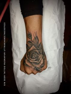 a woman's foot with a rose tattoo on the top of her left hand