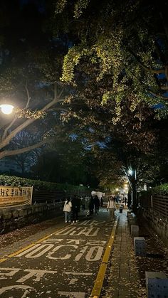 people are walking down the street at night