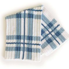 two blue and white dishcloths sitting next to each other