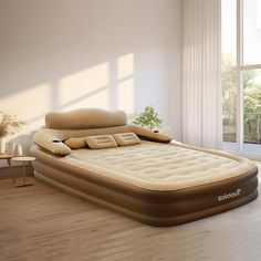 an inflatable bed sitting on top of a wooden floor next to a window