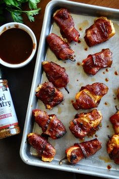 bacon wrapped chicken on a baking sheet next to ketchup