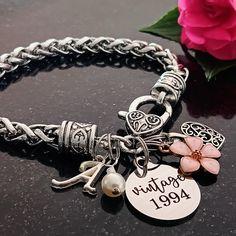 Celebrate her milestone birthday with this sentimental '30th birthday' keepsake. The bracelet features a 'vintage 1994' stainless steel charm, flower, filigree heart, cream pearl, and an initial for personalization. Thirtieth birthday gift for Wife, Spouse, Girlfriend, Cousin, Best Friend, Mother, Daughter, Sister, Aunt, Niece, Family member, Friend, Boss, or Coworker. Gift from Spouse, Husband, Mother, Father, Grandmother, Grandfather, Uncle, Sister, Brother, Aunt, Niece, Coworker, Family, or Friend.  Finishes: Silver Materials: *7.87 inch wheat bracelet *'vintage 1994' stainless steel *filigree heart, pink enamel flower, script initial, zinc alloy *cream pearl, 6mm Gift Packaging: The bracelet will arrive in an organza drawstring bag inside a white box with a gold stretch ribbon on a car Personalized Vintage Jewelry For Birthday, Vintage Personalized Jewelry For Birthday, Jubilee Charm Bracelet For Anniversary On Mother's Day, Mother's Day Anniversary Charm Bracelet, Mother's Day Anniversary Charm Bracelet With Birthstone, Mother's Day Birthstone Charm Bracelet For Anniversary, Mother's Day Anniversary Birthstone Charm Bracelet, Valentine's Day Anniversary Jubilee Charm Bracelet, Mother's Day Birthstone Charm Bracelet For Birthday