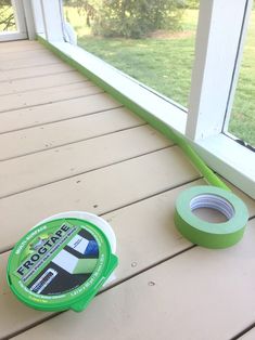 a roll of tape sitting on top of a wooden floor next to a window sill