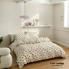 a bed sitting in a bedroom next to a window with white walls and wooden floors