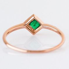 a gold ring with a green stone in the center