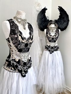 two mannequins dressed in black and white with feathers on their head, one wearing a dress