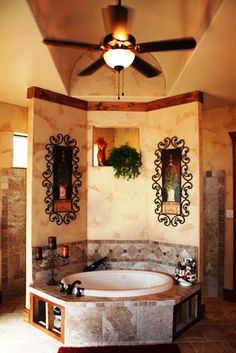 a bathroom with a large jacuzzi tub next to a ceiling fan and two mirrors