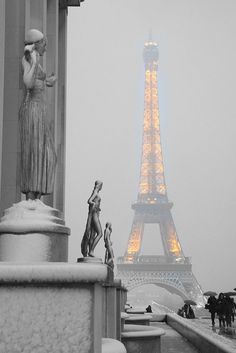 the eiffel tower is lit up in the snow