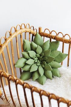 a large green flower sitting on top of a white rug next to a wicker chair