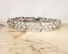 "Offering an EXQUISITE high-end designer \"ORA\" crystal rhinestone encrusted vintage Art Deco bracelet perfect for the bride or with a pair of jeans and a tee. \"ORA\" opened its doors in 1921 and is known for their Art Deco designs, quality material, and excellent craftsmanship. This collectible beyond stunning bracelet features geometric rhodium plated links that are lavishly encrusted with pave set BRILLIANTLY clear sparkly crystal rhinestones. Bracelet closes with a rhinestone adorned fold Vintage Wedding Bracelets With Single Cut Diamonds, Vintage Single Cut Diamond Bracelets For Wedding, Vintage Diamond Bracelet With Accents For Anniversary, Vintage Diamond Bracelet With Single Cut Diamonds For Wedding, Vintage Diamond Bracelet With Accents, Vintage Diamond Bracelet With Diamond Accents, Vintage Cubic Zirconia Bracelets With Diamond Accents, Victorian Diamond Wedding Bracelets, Vintage Sparkling Diamond Jewelry