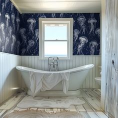 a bathroom with blue and white wallpaper has a claw foot tub in the center