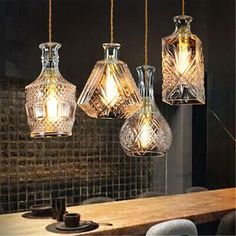 four glass vases hanging from a wooden table