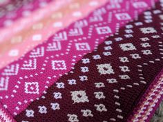 the blanket is made up of different colors and patterns, including pinks, purples, and browns