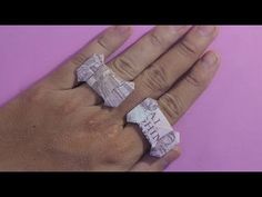 a person's hand with two rings made out of money