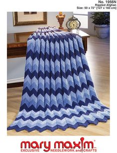 a blue and white chevroned afghan on a wooden floor with a clock in the background