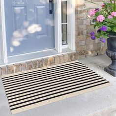 a door mat with flowers on it in front of a house