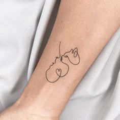 a woman's arm with a tattoo on it that has two cats in the shape of hearts