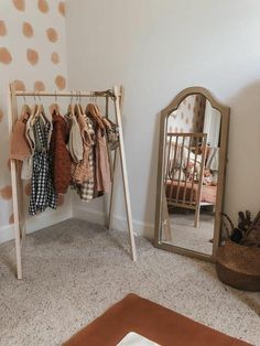 a baby's room with a mirror and clothes rack