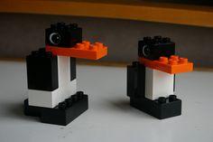 two black and white legos sitting on top of a table next to each other