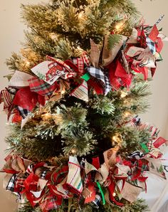 a christmas tree decorated with red, white and green ribbons