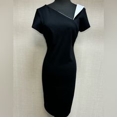 A Stylish Asymmetrical Neckline And Folded Contrasting Detail At The Left Shoulder Add A Unique Touch To This Sheath Dress. With A Convenient Back Zipper Opening, This Dress Is Easy To Slip Into, Ensuring A Seamless And Stylish Look For Any Occasion. Black/Vanilla Cold Water Wash Chic Fitted Asymmetrical Dress For Formal Occasions, Chic Fitted Asymmetrical Dress For Formal Events, Asymmetrical Fitted Mini Dress For Formal Occasions, Dressy Fitted Asymmetrical Dress, One-shoulder Fitted Mini Dress For Work, Modern Knee-length Asymmetrical Dress For Formal Occasions, Fitted One-shoulder Mini Dress For Work, Modern Fitted Knee-length Asymmetrical Dress, Fitted Asymmetrical Sheath Dress For Evening