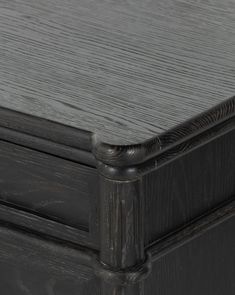 a close up of a black dresser with woodgrain on the top and bottom