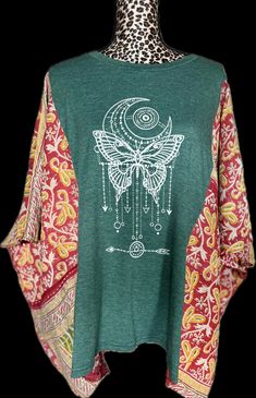 Get ready to spread your wings and fly high in our Celestial Butterfly shirt! With its stunning butterfly design and intricate details, you'll be the talk of the town. *Handmade; Hand sewn. Made from up-cycled imported kantha quilt! One-Size-Fits-All. Bohemian Patchwork Tops With Relaxed Fit, Green Patchwork Tops For Festival, Long Sleeve Bohemian T-shirt In Relaxed Fit, Bohemian Cotton Tops With Butterfly Print, Butterfly Shirts, Kantha Quilt, Butterfly Design, Hand Sewing, Womens Clothing Tops