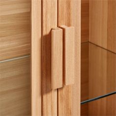 a wooden cabinet with glass doors and handles on the front door is shown in this close up view