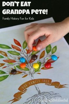 a child's hand is painting a tree with candy