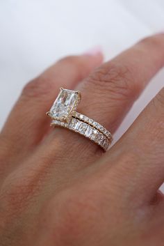 a woman's hand with an engagement ring and wedding band