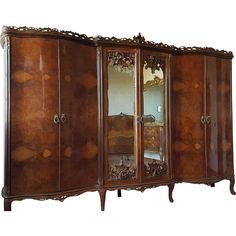 an ornate wooden armoire with mirrors on it