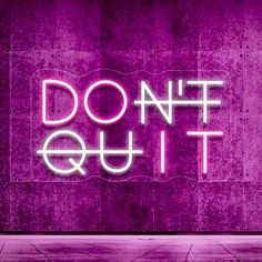 a neon sign that says don't quit on it in front of a purple wall