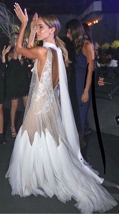 the back of a woman's dress as she walks in front of other people