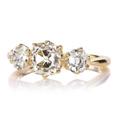 three stone diamond ring in yellow gold with two diamonds on each side and an oval shaped center