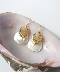 "Vacation vibes are high with our Seycha Resort Earrings. Layers of Mother of Pearl and Gold Monstera leaves give this style a rich yet breezy appearance. This lightweight design is full or movement and shimmer. Our Seycha Collection also includes: Huggie Hoops >> https://www.etsy.com/listing/1155094970 Larger Hoops >> https://www.etsy.com/listing/1169428021 Pendant necklace >> https://www.etsy.com/listing/1169592517 MATERIALS Mother of Pearl, 14k Gold Filled wires, Heavy Gold Plate Charms (anti Elegant Dangle Earrings For Vacation, Elegant Earrings With Ear Wire For Vacation, Elegant Gold Earrings For Vacation, Mother Of Pearl Drop Necklace, Gold Monstera Leaf, Monstera Leaf Earrings, Pearl Earrings Gold, Tropical Jewelry, Pearl Drop Necklace