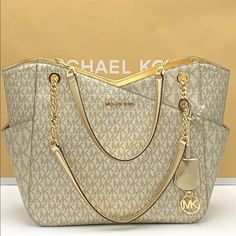 Michael Kors Large X Chain Shoulder Tote Bag Pale Gold Color Destined To Go Places, This Signature-Print Jet Set Shoulder Bag Will Lend Architectural Flair To Everyday Looks. Convenient Side Pockets And A Secure Top-Zip Fastening Render This Carryall The Perfect Travel Companion, While A Spacious Interior Boasts More Than Enough Room For Your Daily Essentials. Details Shoulder Bag Logo-Print Canvas 89.4% Coated Canvas/9.6% Polyester/1% Polyurethane Gold -Tone Hardware 15.6”W X 11”H X 5.5”D Handl Gold Shoulder Bag With Metal Logo For Everyday Use, Gold Shopping Bag With Chain Strap, Michael Kors Gold Shoulder Bag With Gold-tone Hardware, Gold Shoulder Bag With Branded Hardware For Shopping, Elegant Michael Kors Bags With Metal Logo, Gold Tote Bag With Chain Strap, Michael Kors Gold Shoulder Bag For Everyday Use, Michael Kors Gold Shoulder Bag, Gold Michael Kors Shoulder Bag For Everyday