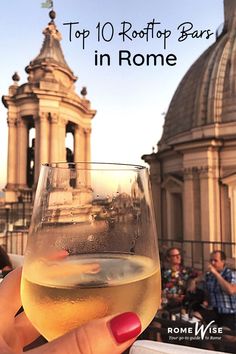 a woman holding up a wine glass in front of a building