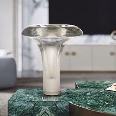 a table with a green marble top and a white vase sitting on it's side